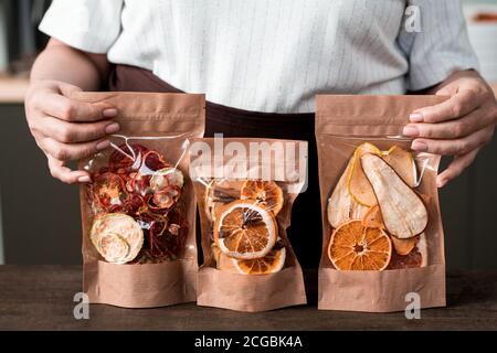 Close-up of unrecognizable woman presenting packages of sweet dried fruit mixture, healthy food Stock Photo
