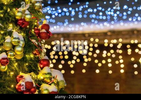 Decorated Christmas tree on blurry background with shiny lights bokeh Stock Photo