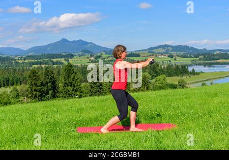Pilates excercises on a meadow in summer Stock Photo