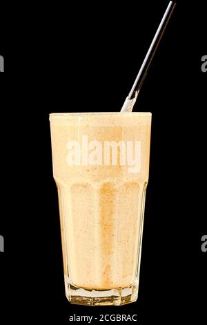 Brown Smoothie or cocktail with coffee and yogurt in a large glass glass on a black background, isolated. Stock Photo