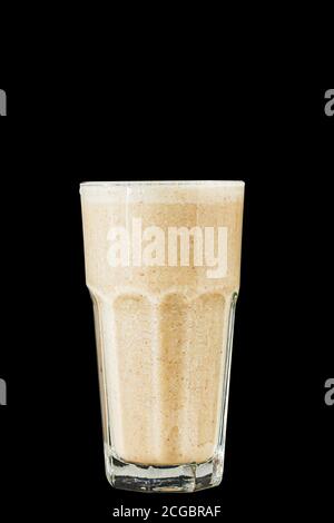 Brown Smoothie or cocktail with coffee and yogurt in a large glass glass on a black background, isolated. Stock Photo