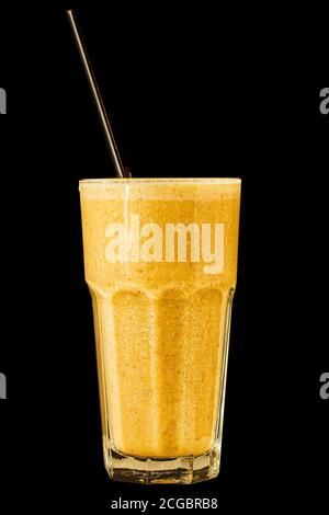Orange citrus smoothie in a large glass glass on a black background, isolated. Stock Photo