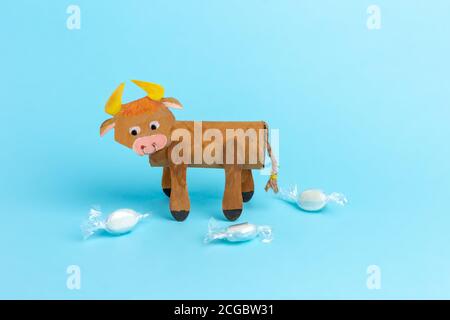 bull or ox made by kids from toilet paper roll, tutorial, DIY, step by step instruction, original packaging for sweets Stock Photo