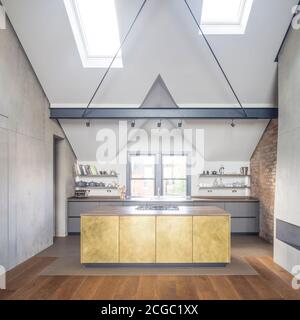 Bespoke brass kitchen of a refurbished top floor flat of a large detached Victorian property and attic conversion including new dormer extension to form new two-storey loft, in London, UK. Stock Photo