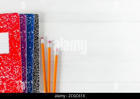 Wooden pencils and colorful composition books on white background. Stock Photo