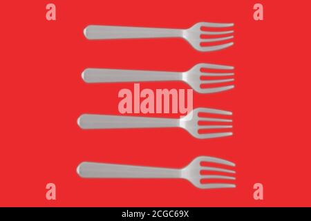 four plastic white forks on a red background Stock Photo
