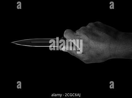 Closeup Hand Holding a Combat Knife Isolated on Black Background, Black and White with Clipping Path Stock Photo