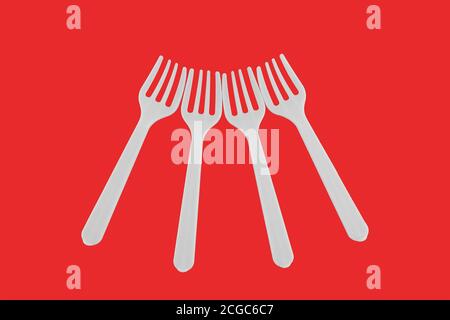 four plastic white forks on a red background Stock Photo