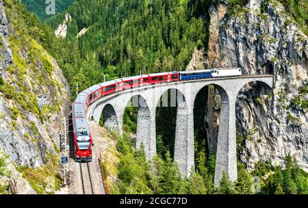 Passenger train crossing the Landwasser Viaduct in Switzerland Stock Photo