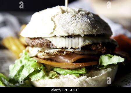 Hamburger with egg and whole tomato, fast food, beef Stock Photo