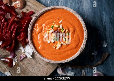 high angle view of an earthenware bowl with fresh made spanish salmorejo cordobes or porra antequerana, a cold tomato soup topped with serrano ham, bo Stock Photo