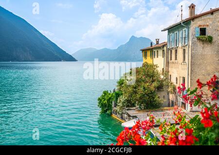 Colorful houses and flowers of Gandria village and scenic view of Lake Lugano on summer day in Ticino Switzerland Stock Photo