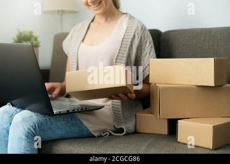 selling from home. small business entrepreneur woman checking and packing mailing box for shipping from online store Stock Photo