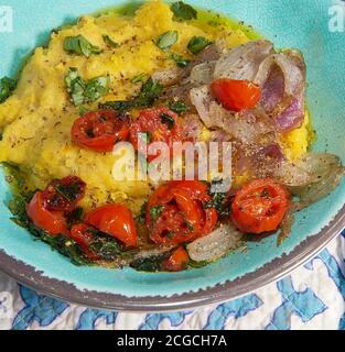 Greek Fava.Yellow split pea puree with cherry tomatoes and caramelized onions ,garnished with parsley. Mediterranean traditional meal. Stock Image. Stock Photo