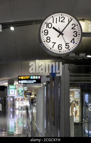 The clock hang over a empty corridor in the airport. Stock Photo