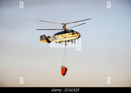 Kamov Ka-32A11BC helicopter (registration EC-JSQ) carrying water for fire fighting, Cabopino Golf, Costa del Sol, Malaga Province, Andalucia, Spain. Stock Photo