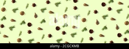 Pine cone Christmas background on green. Pine branches and cones. minimal creative cone arrangement pattern. flat lay, Modern christmas Background. Stock Photo