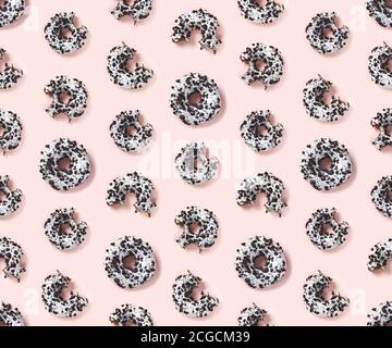 quality seamless pattern of donuts on a pink background top view. Flat lay of delicious nibbled chocolate donuts. Stock Photo