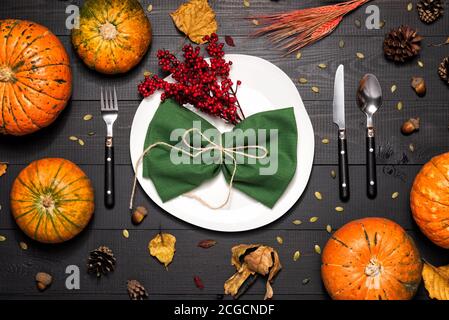 Autumn table setting with empty white plate and pumpkins. Stock Photo