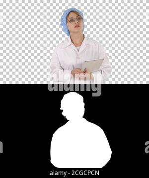 Woman doctor holding tablet and walking, Alpha Channel Stock Photo