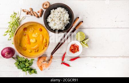 Top view composition of Thai prawns in yellow curry served in bowl, free space for text Stock Photo