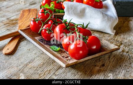 vine tomatoes on wooden rustic table Stock Photo