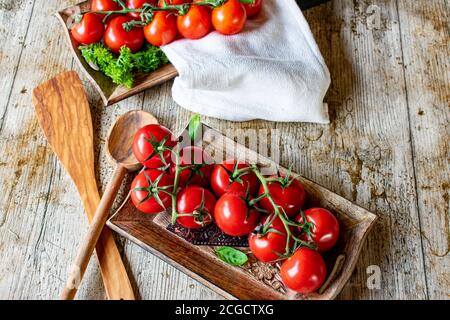 a branch of fresh tomatoes on wooden table from above Stock Photo