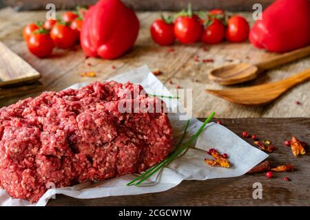 fresh and raw minced meat, ground beef from a butcher on wooden table background Stock Photo