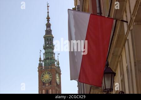 Gdansk, North Poland - August 15, 2020: A polish flag in front of famous St mary church Stock Photo