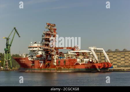 Gdansk, North Poland - August 15, 2020: A big ship with cranes portraying industrial side of city next to motlawa river Stock Photo