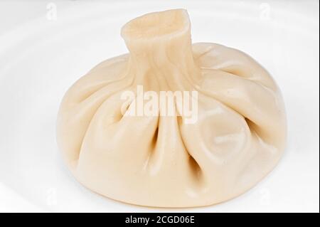 Cooked juicy homemade khinkali dumpling close-up on white plate Stock Photo