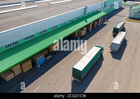 multiple trucks loading at the factory top view. Stock Photo