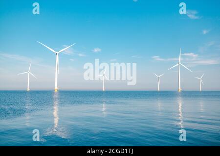 offshore windmill park with stormy clouds and a blue sky, windmill park in the ocean Stock Photo