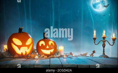 Spooky halloween pumpkins in forest. Scary halloween background with free space for text. Stock Photo