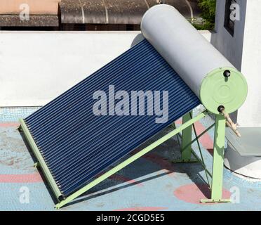 Solar water heater unit consisting of tubular panels and water storage unit installed on the terrace of a building Stock Photo