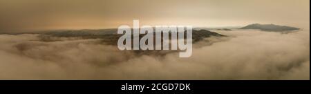 A layer of thick smoke, generated by many wildfires throughout California, darkens the sky above the marine layer over the San Francisco Bay Area. Stock Photo