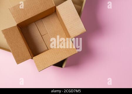 Empty open cardboard boxes on light pink background. Top view Stock Photo