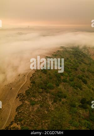 A layer of thick smoke, generated by many wildfires throughout California, darkens the sky above the marine layer over the San Francisco Bay Area. Stock Photo