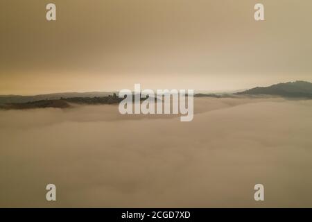 A layer of thick smoke, generated by many wildfires throughout California, darkens the sky above the marine layer over the San Francisco Bay Area. Stock Photo