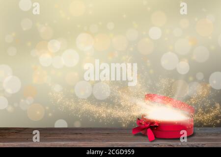 Red open glowing gift box with magic light rays and stars. Christmas backgrounds. Stock Photo