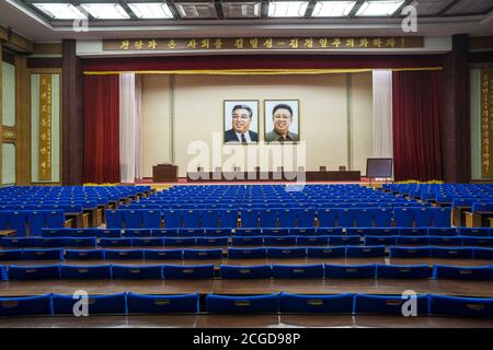 Portraits of Kim Il Sung and Kim Jong Il adorn the wall above a lecture theatre in Pyongyang Stock Photo