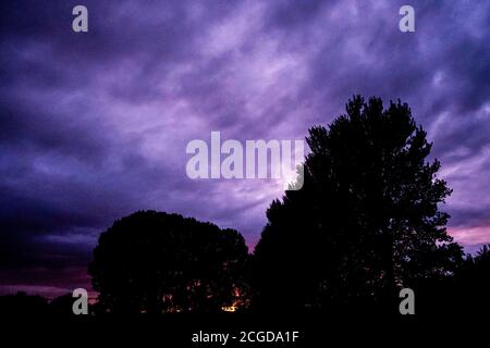Trees against a dramatic cloudy night sky at sunset, West Bridgford, Nottinghamshire, England, UK Stock Photo