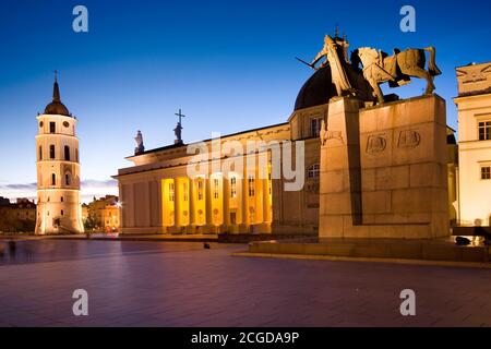 Night view of illuminated Cathedral Square in the Old Town of Vilnius, Lithuania. Cathedral Basilica of St Stanislaus and St Ladislaus on the left, mo