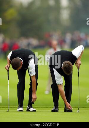 BOTH LEE WESTWOOD AND SERGIO GARCIA CLEAN THEIR SHOES WITH THEIR TEE PEGS. RYDER CUP. THE BELFRY, ENGLAND. 24/9/2002. PICTURE : MARK PAIN / ALAMY Stock Photo