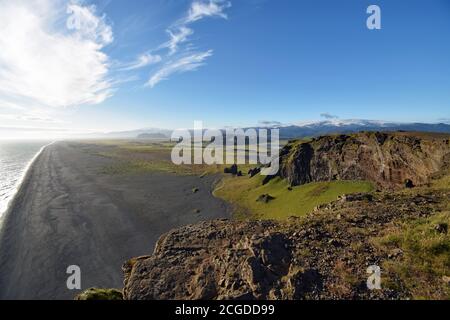 The endless black sand Dyrholaey beach as seen from the cliffs of Dyrholaey.  The Atlantic ocean meets the black sand along the south coast of Iceland. Stock Photo