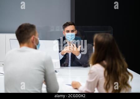 Young Family Couple Meeting Consultant Or Lawyer With Face Masks Stock Photo