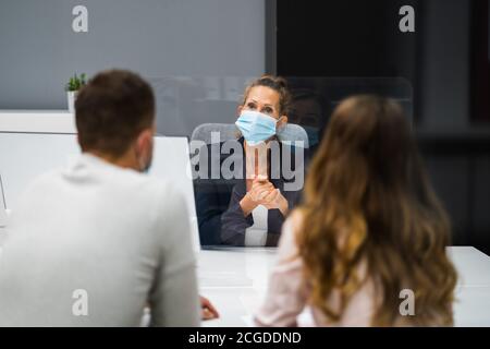 Young Family Couple Meeting Consultant Or Lawyer With Face Masks Stock Photo