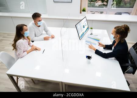 Young Family Couple Meeting Financial Advisor With Face Masks Stock Photo