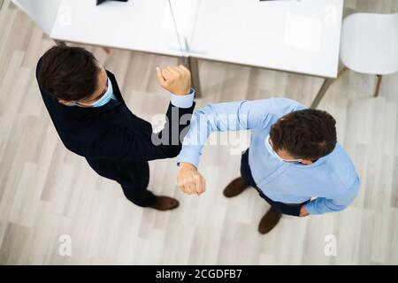 Employees Doing Elbow Bump To Avoid Flu And Stop Covid Spread Stock Photo