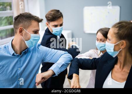 Employees Doing Elbow Bump To Avoid Flu And Stop Covid Spread Stock Photo